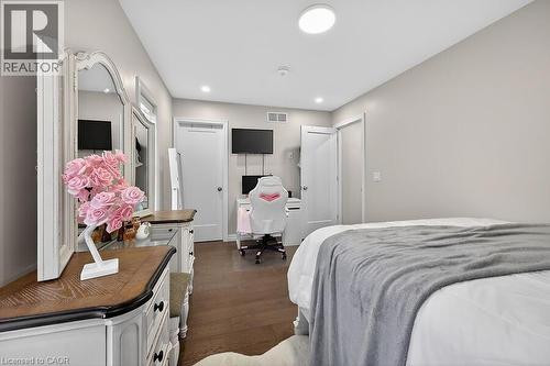 Recessed lighting illuminates wood-finish flooring - 109 Ray Street N, Hamilton, ON - Indoor Photo Showing Bedroom