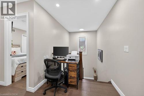 Versatile bonus area featuring rich wood-finish flooring, recessed lighting, a single window with blinds, and white baseboards - 109 Ray Street N, Hamilton, ON - Indoor Photo Showing Office
