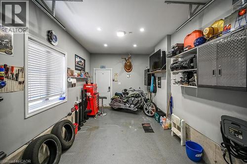 Spacious garage featuring light gray walls, a window with horizontal blinds, and a durable gray textured floor - 109 Ray Street N, Hamilton, ON - Indoor Photo Showing Garage