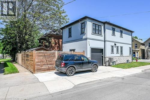 Contemporary stucco exterior with dark trim accents and a stone veneer foundation - 109 Ray Street N, Hamilton, ON - Outdoor