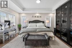 Spacious room featuring tray ceiling, recessed lighting, and wood-finish flooring - 