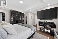 Recessed lighting illuminates the tray ceiling and wood-finish flooring - 