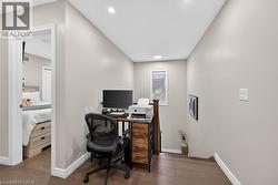 Versatile bonus area featuring rich wood-finish flooring, recessed lighting, a single window with blinds, and white baseboards - 