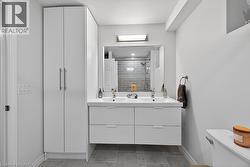 Modern bathroom featuring a double vanity with two rectangular vessel sinks, under-sink storage drawers, and a large wall-mounted mirror - 