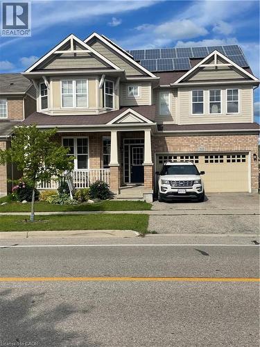 Two-story residence featuring a brick and siding exterior, front porch with columns, a two-car garage, and rooftop solar panels - 222 Baldwin Drive, Cambridge, ON - Outdoor With Exterior