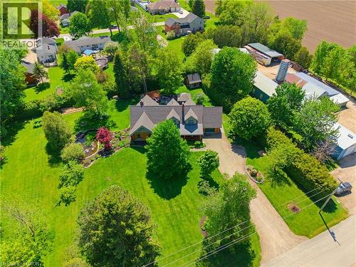 Spacious property featuring a large residence with a multi-gabled roofline, extensive green lawns, and mature trees - 169 James Street, Atwood, ON - Outdoor With View