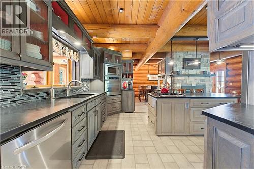 Kitchen featuring light grey cabinetry with dark hardware, stainless steel appliances, a mosaic tile backsplash, and dark countertops - 169 James Street, Atwood, ON - Indoor Photo Showing Kitchen