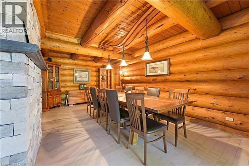 Dining area featuring natural wood-finish log walls and ceiling, exposed timber beams, and light-toned wood-finish flooring - 169 James Street, Atwood, ON - Indoor Photo Showing Dining Room