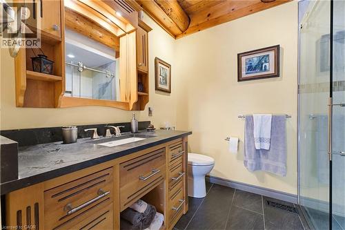 Bathroom featuring a wood vanity with integrated sink, dark stone countertop, and wood-framed mirrored medicine cabinet - 169 James Street, Atwood, ON - Indoor Photo Showing Bathroom