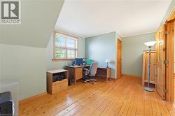 Room featuring wood-finish flooring, a window with blinds, and light-toned walls - 