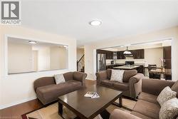 Expansive living area featuring wood-finish flooring and a neutral color palette - 