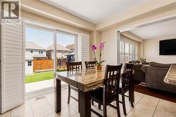 Dining area featuring a stone-look tabletop, tile flooring, and sliding glass doors with plantation shutters - 