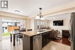 Open concept living space featuring a central kitchen island with a stone countertop and double basin sink - 