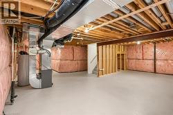 Unfinished basement presenting exposed wood joists and structural beams - 