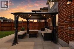 Expansive concrete patio featuring a gazebo with string lighting - 