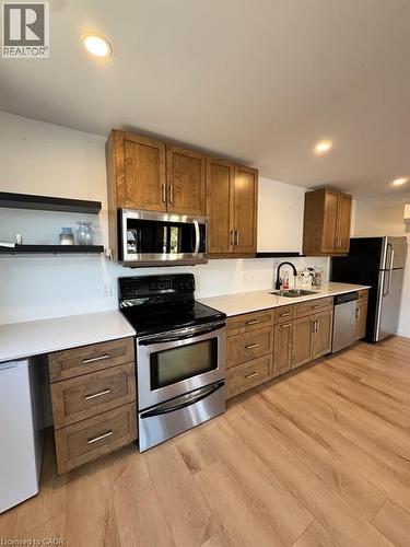 Kitchen featuring wood-finish flooring, white countertops, and wood cabinetry - 431 Krug Street, Kitchener, ON - Indoor Photo Showing Kitchen