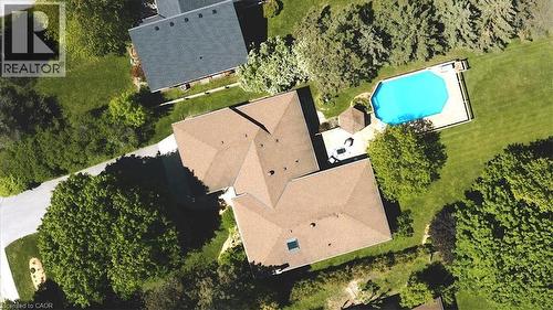 Aerial view showcasing a residential property with a multi-level roofline, a rectangular swimming pool with surrounding decking, and mature landscaping - 26 Sideroad 18, Fergus, ON - Outdoor With View
