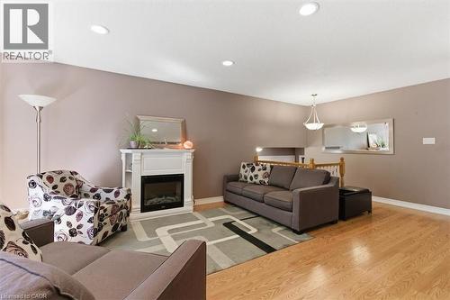 Spacious living area featuring light wood-finish flooring, recessed lighting, and a white decorative fireplace surround with an electric insert - 26 Sideroad 18, Fergus, ON - Indoor Photo Showing Living Room With Fireplace