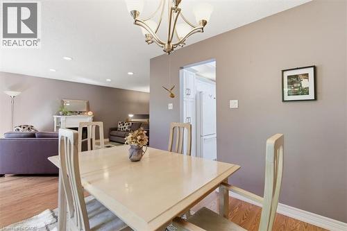 Dining area featuring a contemporary chandelier, wood-finish flooring, and neutral wall tones - 26 Sideroad 18, Fergus, ON - Indoor Photo Showing Dining Room