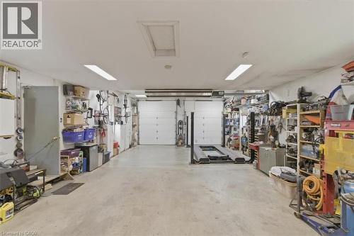 Spacious garage featuring two overhead doors, concrete flooring, and ample overhead lighting - 26 Sideroad 18, Fergus, ON - Indoor Photo Showing Garage