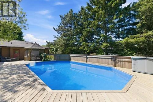 Rectangular in-ground pool surrounded by extensive wood deck - 26 Sideroad 18, Fergus, ON - Outdoor With Above Ground Pool With Backyard