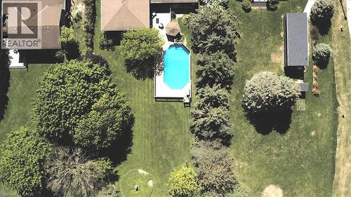 Manicured grounds featuring an inground swimming pool with a surrounding deck, mature trees, and a detached outbuilding - 26 Sideroad 18, Fergus, ON - Outdoor With View