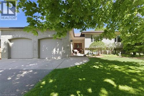 Stone facade featuring a two-car garage with arched entrances - 26 Sideroad 18, Fergus, ON - Outdoor