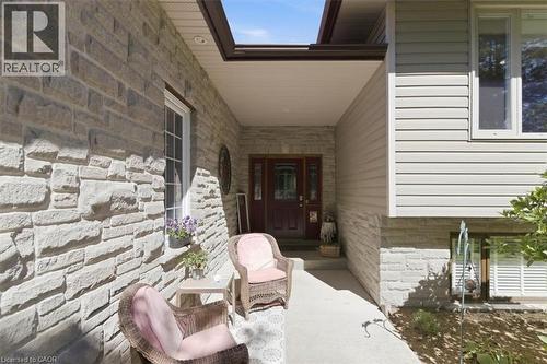 Stone and siding exterior with a covered porch entry, transom window, and double entry doors - 26 Sideroad 18, Fergus, ON - Outdoor
