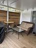 Covered outdoor deck featuring natural wood plank flooring, a horizontal wood plank accent wall, and a durable metal roof - 580 Beaver Creek Road Unit# 203, Waterloo, ON  - Outdoor With Deck Patio Veranda With Exterior 