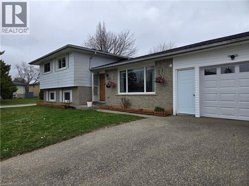Split-level residence featuring a single-car garage with a panel door and upper window inserts - 261 Overlea Drive, Kitchener, ON 