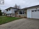 Split-level residence featuring a single-car garage with a panel door and upper window inserts - 261 Overlea Drive, Kitchener, ON 