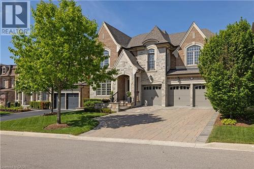 Stone and brick-clad exterior featuring arched windows, multiple gables, and a prominent front entrance - 68 Annsleywood Court, Kleinburg, ON - Outdoor With Facade