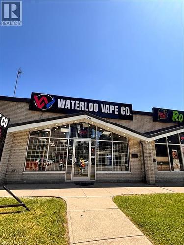 Commercial storefront featuring a prominent illuminated sign, a brick facade, and a glass entrance with large display windows - 29 University Avenue E, Waterloo, ON 