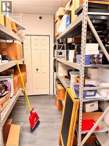 Utility space featuring industrial metal shelving, gray tile flooring, and a white bi-fold door - 29 University Avenue E, Waterloo, ON 