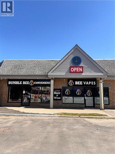 Commercial storefront featuring brick and siding construction, multiple display windows, and a prominent gable roofline with an accent window - 1400 Weber Street E Unit# A5, Kitchener, ON 