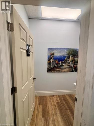 Wood-finish flooring complemented by light-colored walls and a drop ceiling with integrated lighting - 1400 Weber Street E Unit# A5, Kitchener, ON 