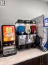 Beverage station featuring a chai dispenser, triple slushie machine, and dedicated cup storage, all set on a light-toned countertop with dark wood-finish cabinetry - 1400 Weber Street E Unit# A5, Kitchener, ON 