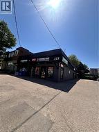 Commercial building with a dark facade, prominent signage, and a paved parking area - 