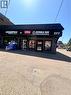 Commercial storefront featuring a dark gray facade and a black corrugated metal awning - 277 Lancaster Street W, Kitchener, ON 