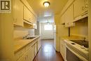 Galley kitchen featuring white cabinetry, laminate countertops, a double-basin stainless steel sink, and a built-in range with overhead ventilation - 223 Heiman Street Unit# Unit 2, Kitchener, ON  - Indoor Photo Showing Kitchen 