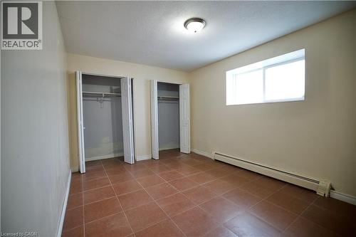 Room featuring two bi-fold door closets, a single window, and a ceiling-mounted light fixture - 223 Heiman Street, Kitchener, ON - Indoor Photo Showing Other Room