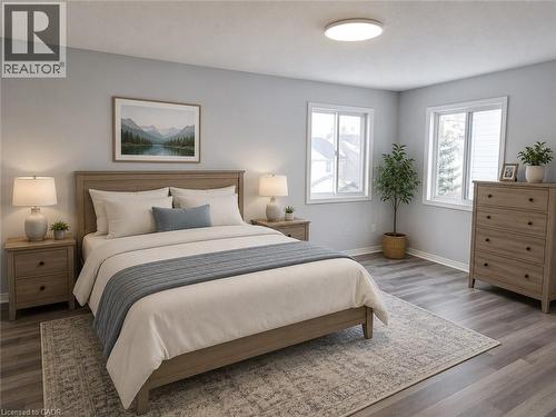 Spacious room featuring wood-finish flooring, light gray wall tones, and two large windows - 732 Angler Way, Waterloo, ON - Indoor Photo Showing Bedroom