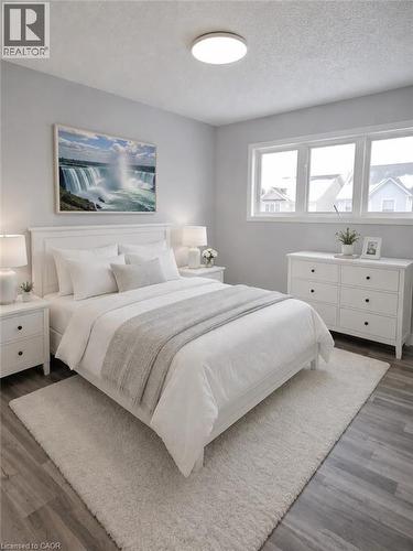 Bedroom with wood-finish flooring, featuring a large window, flush-mount ceiling light, and light gray walls - 732 Angler Way, Waterloo, ON - Indoor Photo Showing Bedroom