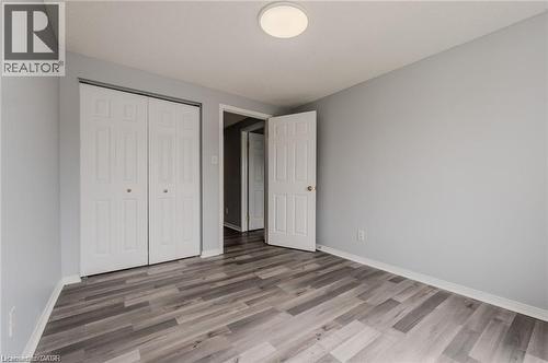 Contemporary interior featuring wood-finish flooring, light gray wall paint, and white trim - 732 Angler Way, Waterloo, ON - Indoor Photo Showing Other Room