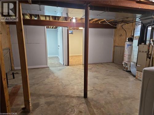 Unfinished basement area with concrete flooring, exposed ceiling joists, and a partial wall separating a finished space with carpet flooring - 732 Angler Way, Waterloo, ON - Indoor Photo Showing Basement