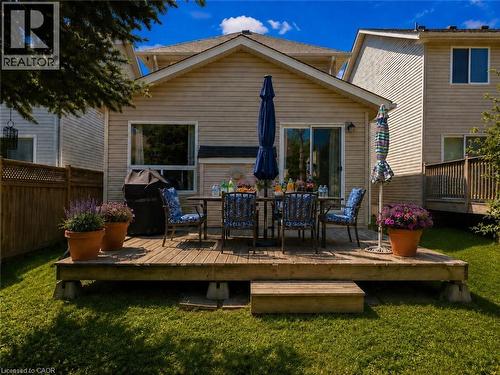 Rear deck with direct yard access, featuring a sliding glass door, a large window, and light-colored siding - 732 Angler Way, Waterloo, ON - Outdoor With Deck Patio Veranda