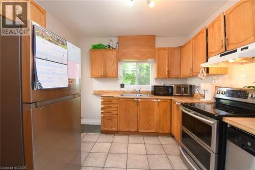 Kitchen featuring light wood cabinetry, a stainless steel electric range, and tile flooring - 12 Wood Street W, Hamilton, ON - Indoor Photo Showing Kitchen With Double Sink