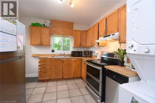 Kitchen featuring wood-finish cabinetry, stainless steel appliances, and a tiled floor - 12 Wood Street W, Hamilton, ON - Indoor