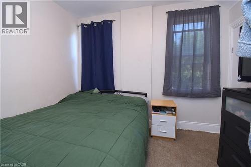 Carpeted room featuring white walls and multiple windows - 12 Wood Street W, Hamilton, ON - Indoor Photo Showing Bedroom