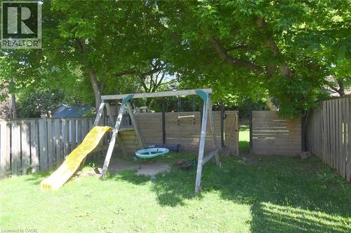 Spacious backyard featuring mature trees, a manicured lawn, and wood fencing - 12 Wood Street W, Hamilton, ON - Outdoor